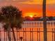 Golden sunset reflecting over the waterfront with a charming pier in the distance at 1784 Bayshore Dr, Englewood, FL 34223