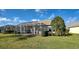 Spacious backyard with screened patio and lush landscaping at 19374 Rizzuto St, Venice, FL 34293