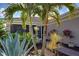 Landscaped entryway with tropical plants and brick walkway at 19374 Rizzuto St, Venice, FL 34293