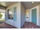 Side entry with teal door, tile floor, and window with shutters at 19374 Rizzuto St, Venice, FL 34293