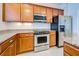 Well-equipped kitchen with stainless steel appliances and wood cabinets at 19374 Rizzuto St, Venice, FL 34293
