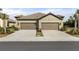 Two-car garage home with light brown exterior and tile roof at 205 Tracino Ter, Nokomis, FL 34275