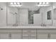 Double vanity bathroom with a large mirror and a view of the shower at 23108 Banbury Way # 202, Venice, FL 34293