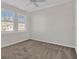 Bedroom with two windows, carpet flooring, and a ceiling fan at 23108 Banbury Way # 202, Venice, FL 34293