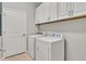 Laundry room with washer, dryer, and upper cabinets at 23108 Banbury Way # 202, Venice, FL 34293