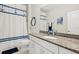 Clean bathroom with granite countertop, shower, and nautical-themed decor at 23471 Awabuki Dr, Venice, FL 34293