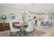 Modern dining room with kitchen view, featuring a wooden table and neutral chairs at 23471 Awabuki Dr, Venice, FL 34293