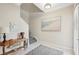 Bright entryway with staircase, console table, and coastal art at 23471 Awabuki Dr, Venice, FL 34293