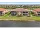 Back exterior of home with lake view and lush landscaping at 23471 Awabuki Dr, Venice, FL 34293