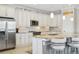 Modern kitchen with white cabinets, granite island and stainless steel appliances at 23471 Awabuki Dr, Venice, FL 34293