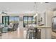 Modern kitchen with island and breakfast bar overlooking living room at 23471 Awabuki Dr, Venice, FL 34293