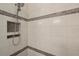 Walk-in shower with gray and white tile and built-in shelves at 23471 Awabuki Dr, Venice, FL 34293