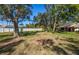 Spacious backyard with mature trees and grassy lawn at 237 Southampton Ln # 275, Venice, FL 34293