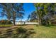 Large backyard with mature trees and a white fence at 237 Southampton Ln # 275, Venice, FL 34293