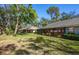 Landscaped backyard with lush lawn and mature trees at 237 Southampton Ln # 275, Venice, FL 34293