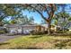 A three-car garage, mature landscaping, and a spacious yard with large oak trees at 237 Southampton Ln # 275, Venice, FL 34293