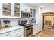 Modern white kitchen with stainless steel appliances and a view of the dining area at 237 Southampton Ln # 275, Venice, FL 34293