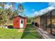 View of the backyard featuring a shed, outdoor grills, and a glimpse of the screened-in pool at 2737 Cottage Ln, North Port, FL 34286