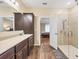 Bathroom featuring double vanity, glass shower, and view into main bedroom at 2737 Cottage Ln, North Port, FL 34286
