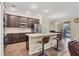 An open-concept kitchen boasts an island with bar seating, stainless steel appliances, and wood floors at 2737 Cottage Ln, North Port, FL 34286