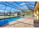 Gorgeous screened-in pool area with brick patio, hot tub, and a backyard shed at 2737 Cottage Ln, North Port, FL 34286