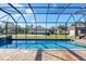 Stunning screened-in pool area with brick patio, hot tub, and a lush backyard at 2737 Cottage Ln, North Port, FL 34286
