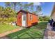 Exterior of the shed with wood siding, a white door, and a small window at 2737 Cottage Ln, North Port, FL 34286