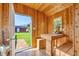 Interior of the shed featuring wood-paneled walls, a table with benches, and a view of the backyard at 2737 Cottage Ln, North Port, FL 34286