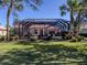 Home's backyard with screened enclosure, lush landscaping, and a partially visible pool at 298 Montelluna Dr, North Venice, FL 34275