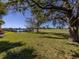 Landscaped backyard with a large oak tree and view of a pond and golf course at 298 Montelluna Dr, North Venice, FL 34275