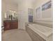 Relaxing bathroom with soaking tub, shower, and dark wood cabinets at 298 Montelluna Dr, North Venice, FL 34275