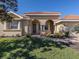 One-story house with arched entryway, tile roof, and lush landscaping at 298 Montelluna Dr, North Venice, FL 34275