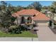 Tan one-story house with a tile roof, arched entryway, and landscaped yard at 298 Montelluna Dr, North Venice, FL 34275