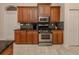 Kitchen with wood cabinets, granite counters, and stainless steel appliances at 298 Montelluna Dr, North Venice, FL 34275