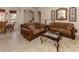 Spacious living room with two brown sofas and a glass-top coffee table at 298 Montelluna Dr, North Venice, FL 34275