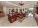 Spacious living room with leather sectional sofa, tile floors, and views to the backyard at 298 Montelluna Dr, North Venice, FL 34275