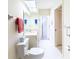 Bathroom with tiled walk-in shower, white vanity with a mirror, commode, and sliding glass door at 301 Pinebrook Club Dr # 1, Venice, FL 34285