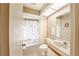 Bright bathroom featuring a shower-tub combo, vanity, and natural light at 301 Pinebrook Club Dr # 1, Venice, FL 34285