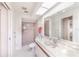 Bathroom with tiled walk-in shower, white vanity with a large mirror, and white commode at 301 Pinebrook Club Dr # 1, Venice, FL 34285