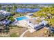 Aerial view of the community pool, adjacent recreation building, and a tranquil lake at 301 Pinebrook Club Dr # 1, Venice, FL 34285