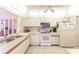 Bright kitchen featuring white cabinetry, appliances, and a tray ceiling at 301 Pinebrook Club Dr # 1, Venice, FL 34285