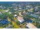 An aerial view of a charming home surrounded by mature trees, lush greenery, and neighboring houses at 3151 Datura Rd, Venice, FL 34293