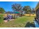 Landscaped backyard with grill, outdoor dining area, and well-maintained lawn at 3151 Datura Rd, Venice, FL 34293
