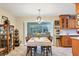 Open-concept dining area with an inviting table setting, adjoining a kitchen with wood cabinetry and bright lighting at 3151 Datura Rd, Venice, FL 34293