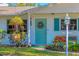 Close-up of a charming front door with turquoise paint, decorative wreath, and potted plants enhancing its appeal at 3151 Datura Rd, Venice, FL 34293