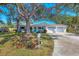 Charming home featuring a well-maintained front yard, mature tree, and a two-car garage, all under a sunny, clear sky at 3151 Datura Rd, Venice, FL 34293