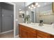 Double vanity bathroom with wood cabinets and a large mirror at 320 Langholm Dr, Venice, FL 34293