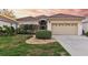 One-story home with tile roof, attached garage, and landscaped lawn at 320 Langholm Dr, Venice, FL 34293