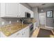Kitchen with granite countertops, white cabinets, and stainless steel appliances at 320 Langholm Dr, Venice, FL 34293
