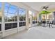 Relaxing screened porch with ceiling fan and outdoor furniture at 320 Langholm Dr, Venice, FL 34293